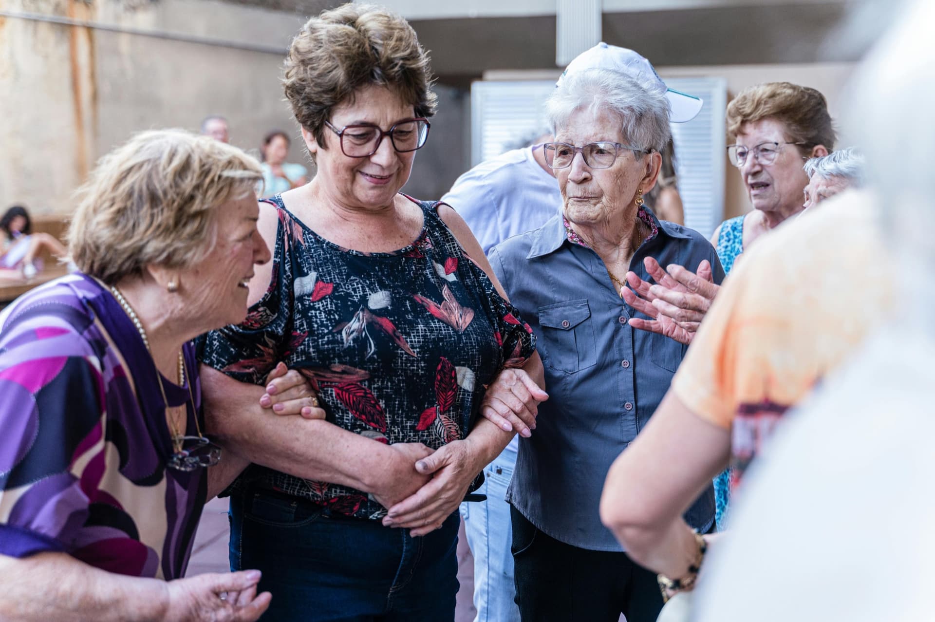 Older women linking arms at a bingo gathering