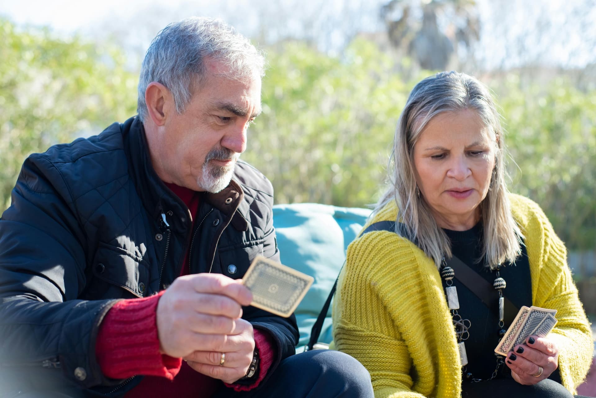 Older couple playing cards outside